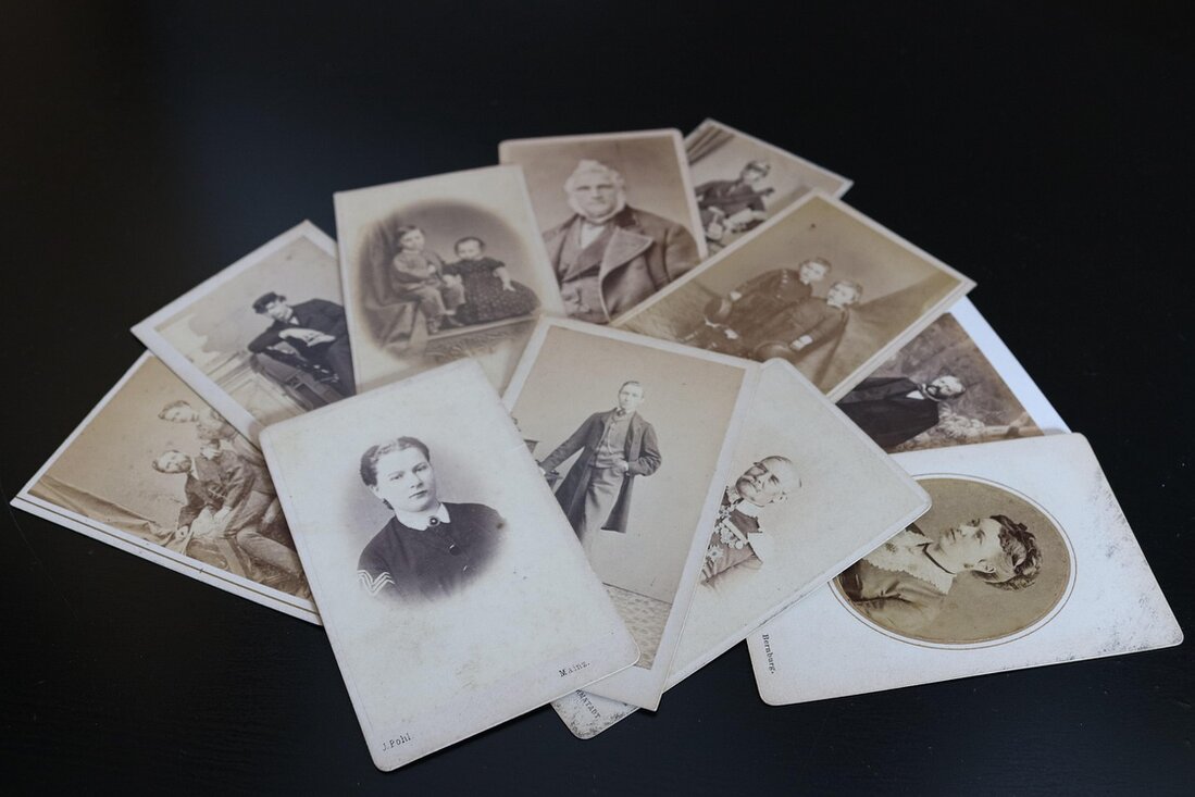 Old family photographs spread out on a wooden table